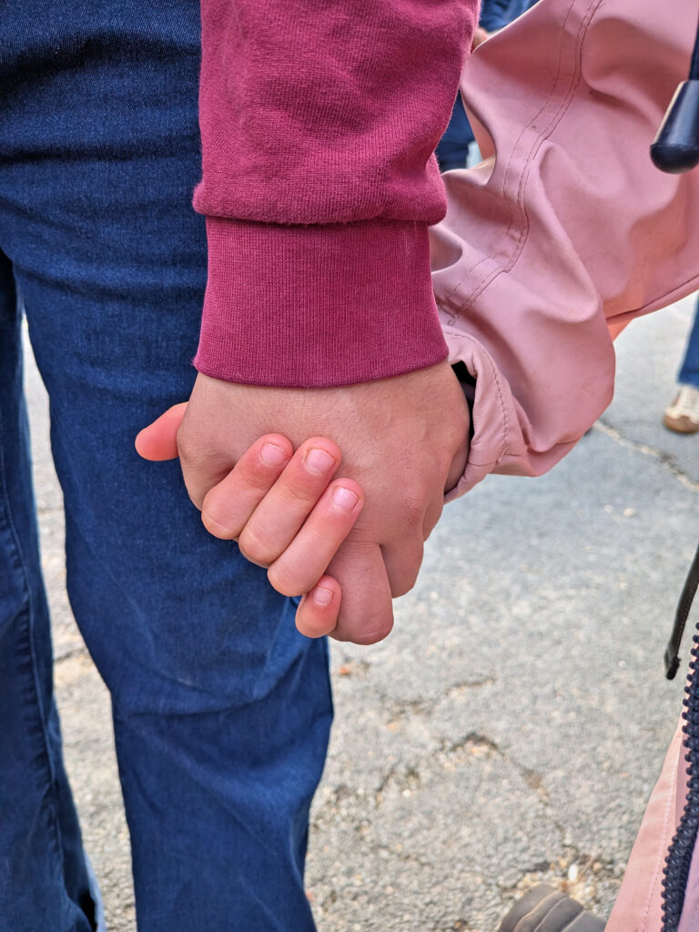 Main dans la main : un collégien et un plus jeune élève pendant la marche