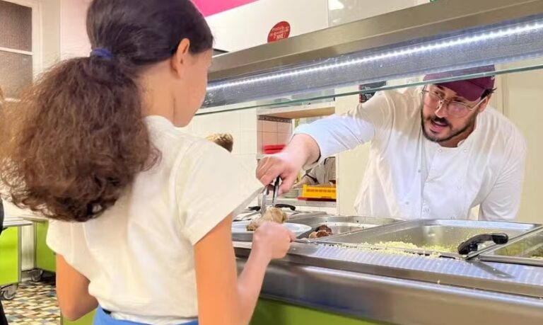 Le cuisinier Mickaël Gei sert une élève au restaurant scolaire