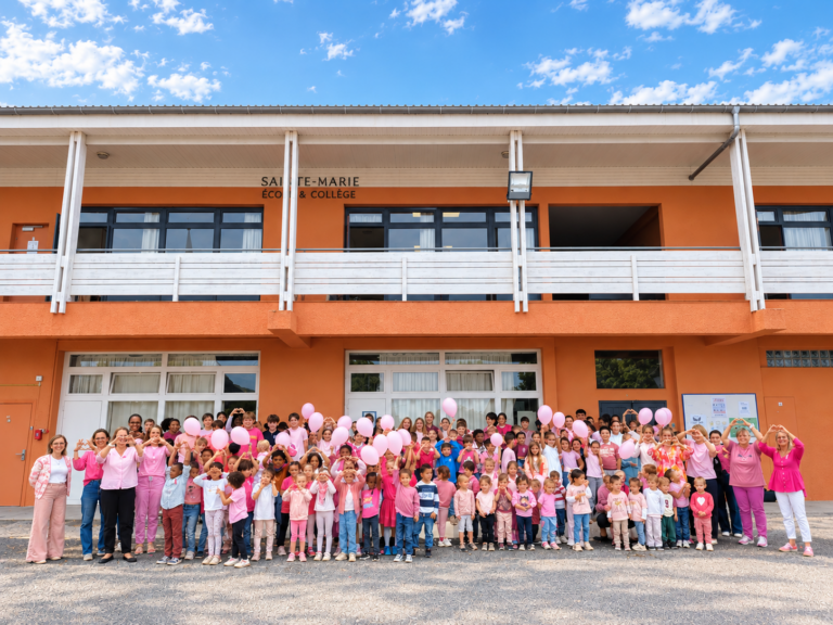 Toute l’école habillée en rose devant le bâtiment