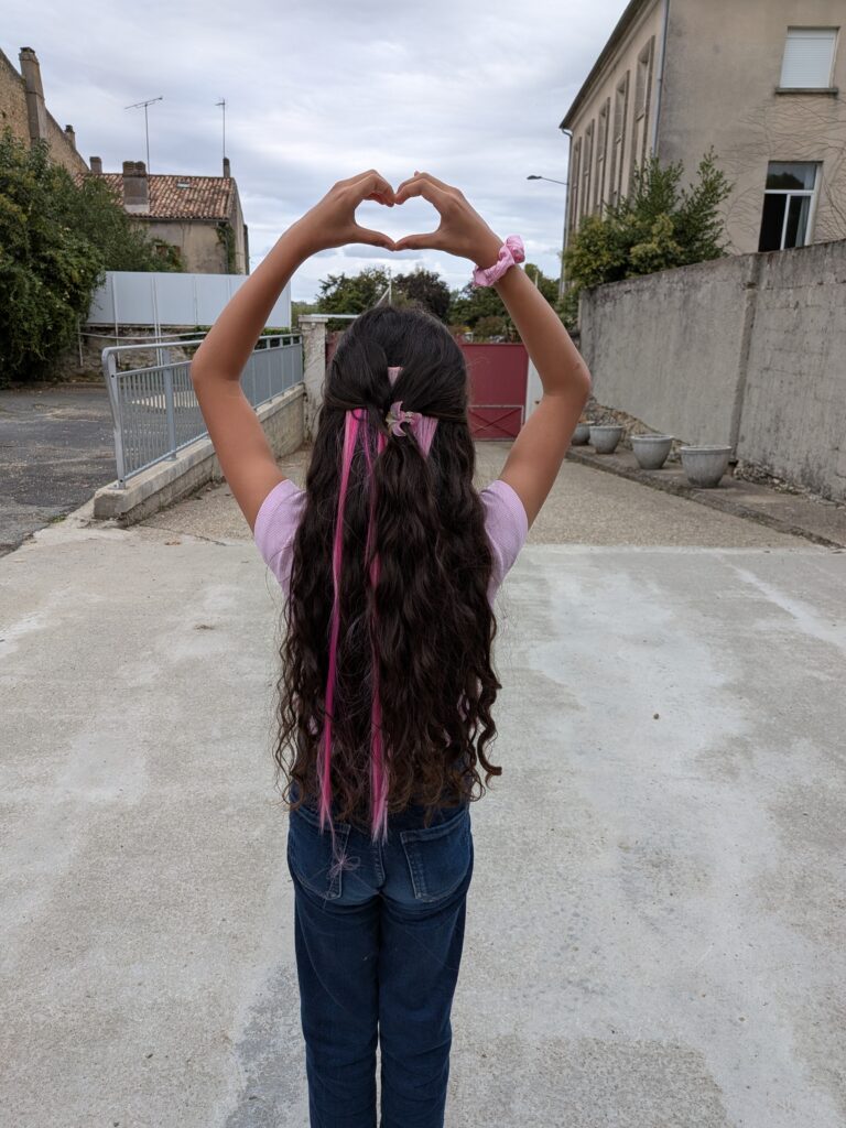 Une élève fait un cœur avec ses mains